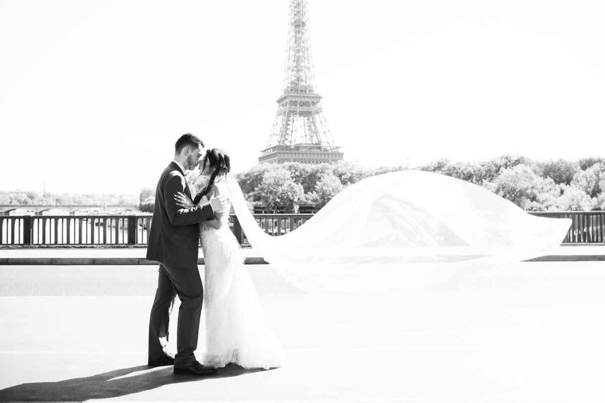 Mariés enlacés devant la tour Eiffel, portrait de mariage en noir et blanc