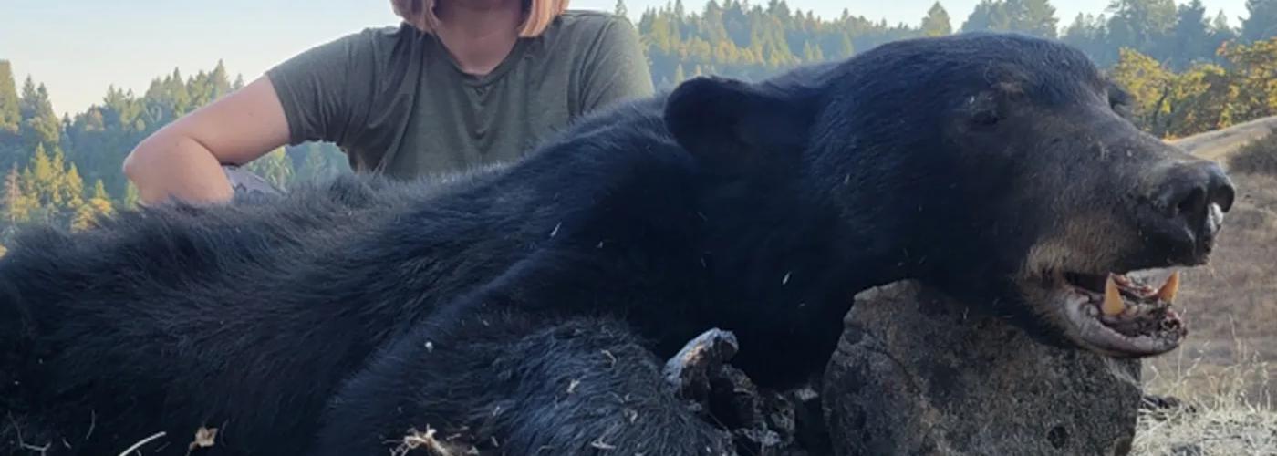 Hunter shown with black bear after a guided California black bear hunt.