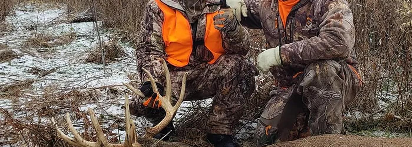 Mature whitetail buck standing in an Iowa cornfield during a guided deer hunt.