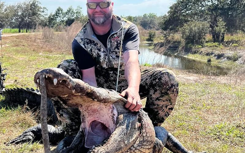 Florida hunter with a large alligator after a guided swamp hunt