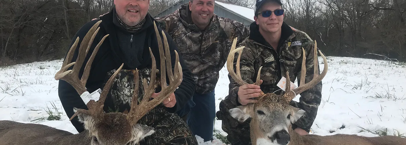 Mature whitetail buck standing in an Illinois agricultural field during a guided deer hunt.