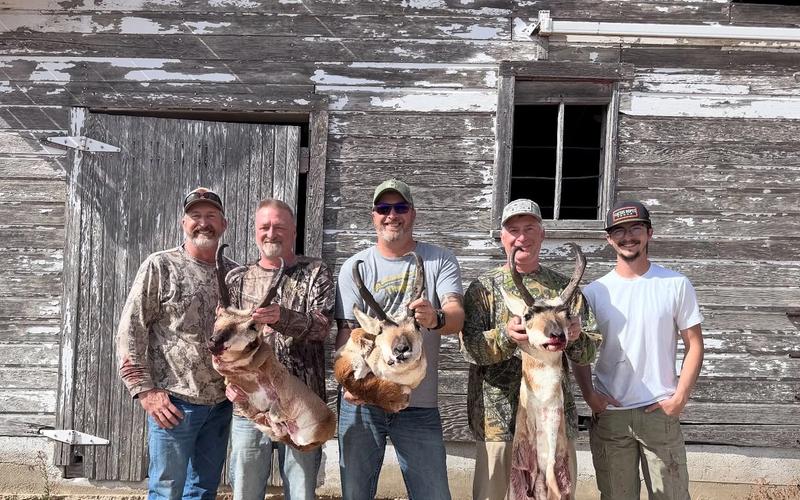 Hunters with harvested pronghorn antelope on private Western ranch land