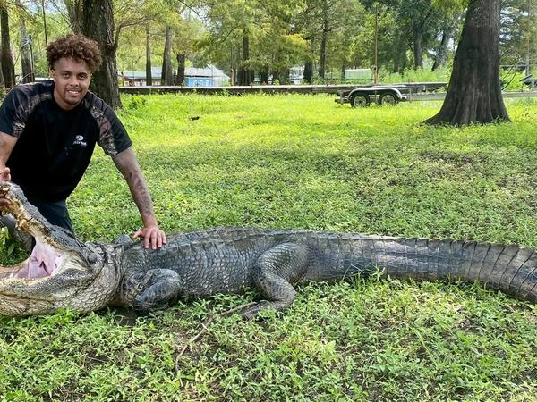 Alligator hunter posing with harvested gator during a guided hunt in the South