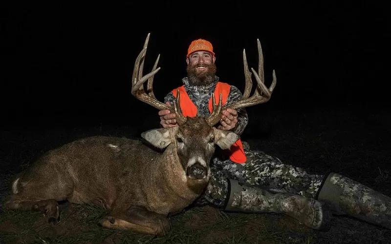 Hunter with a mature Oklahoma whitetail buck in wooded prairie habitat