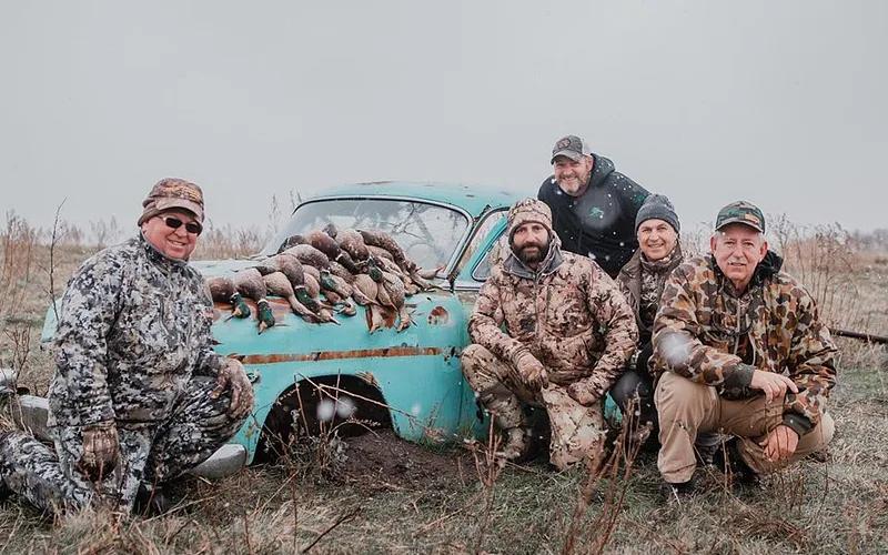 Duck hunters posing with ducks after a successful dry field hunt in North Dakota.