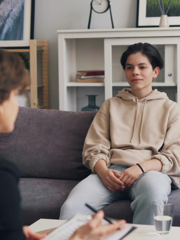 Un colloquio nello studio: la psicologa ascolta una ragazza seduta sul divano