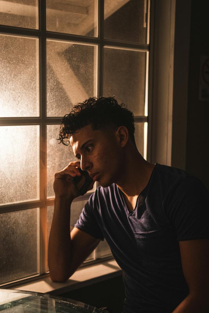 Ragazzo pensieroso vicino a una finestra