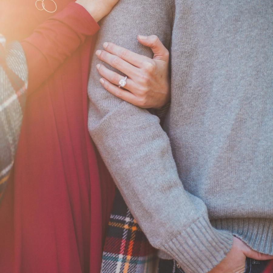 Mano di una donna appoggiata sulla spalla del compagno