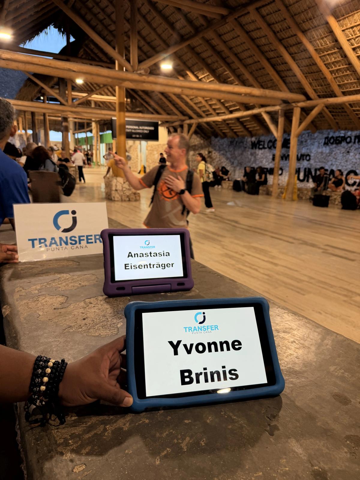 CJ Transfer driver holding personalized greeting board welcoming tourists at Punta Cana Airport arrivals