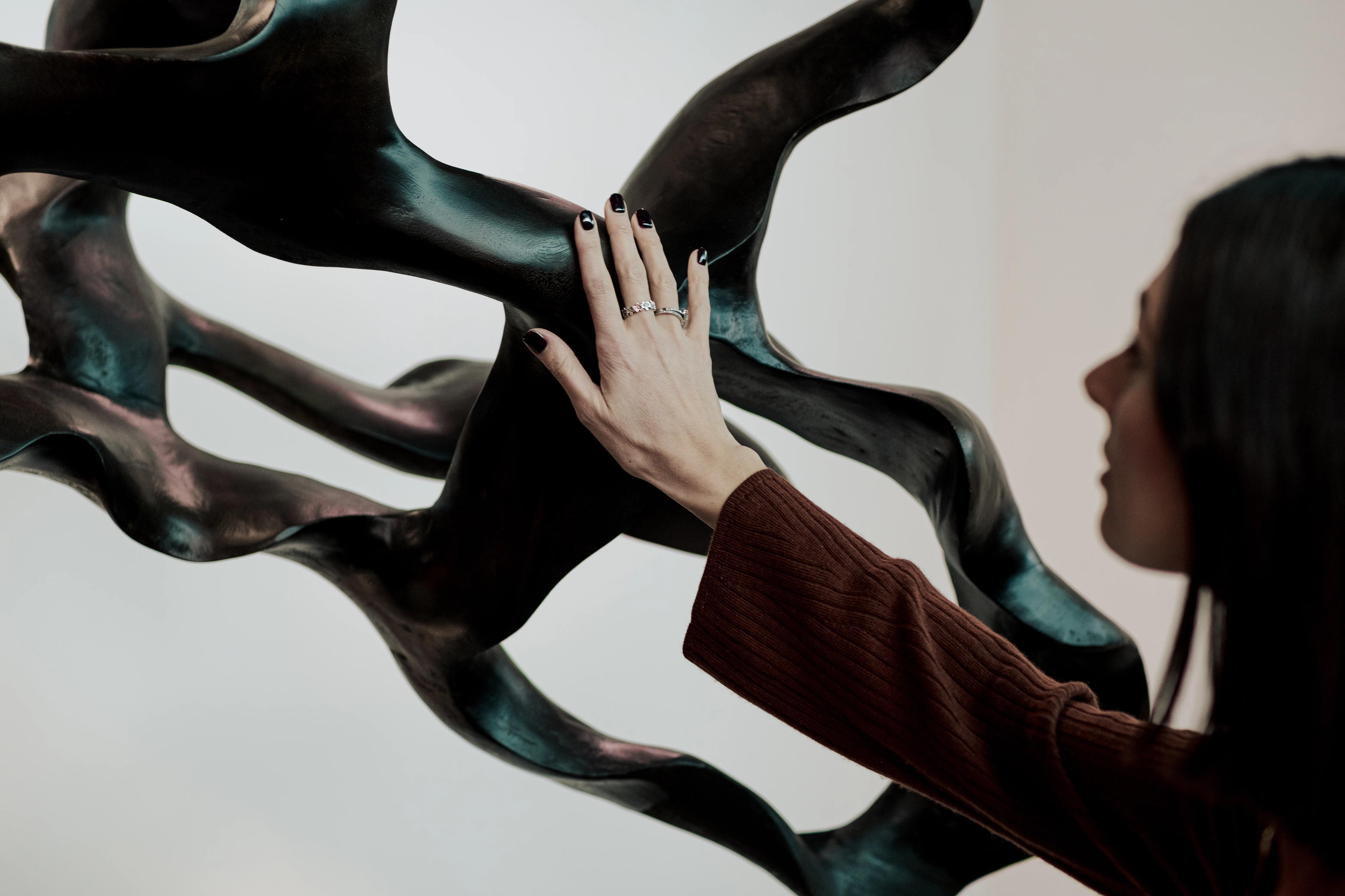 Mano femminile che tocca scultura in legno di Cabbia