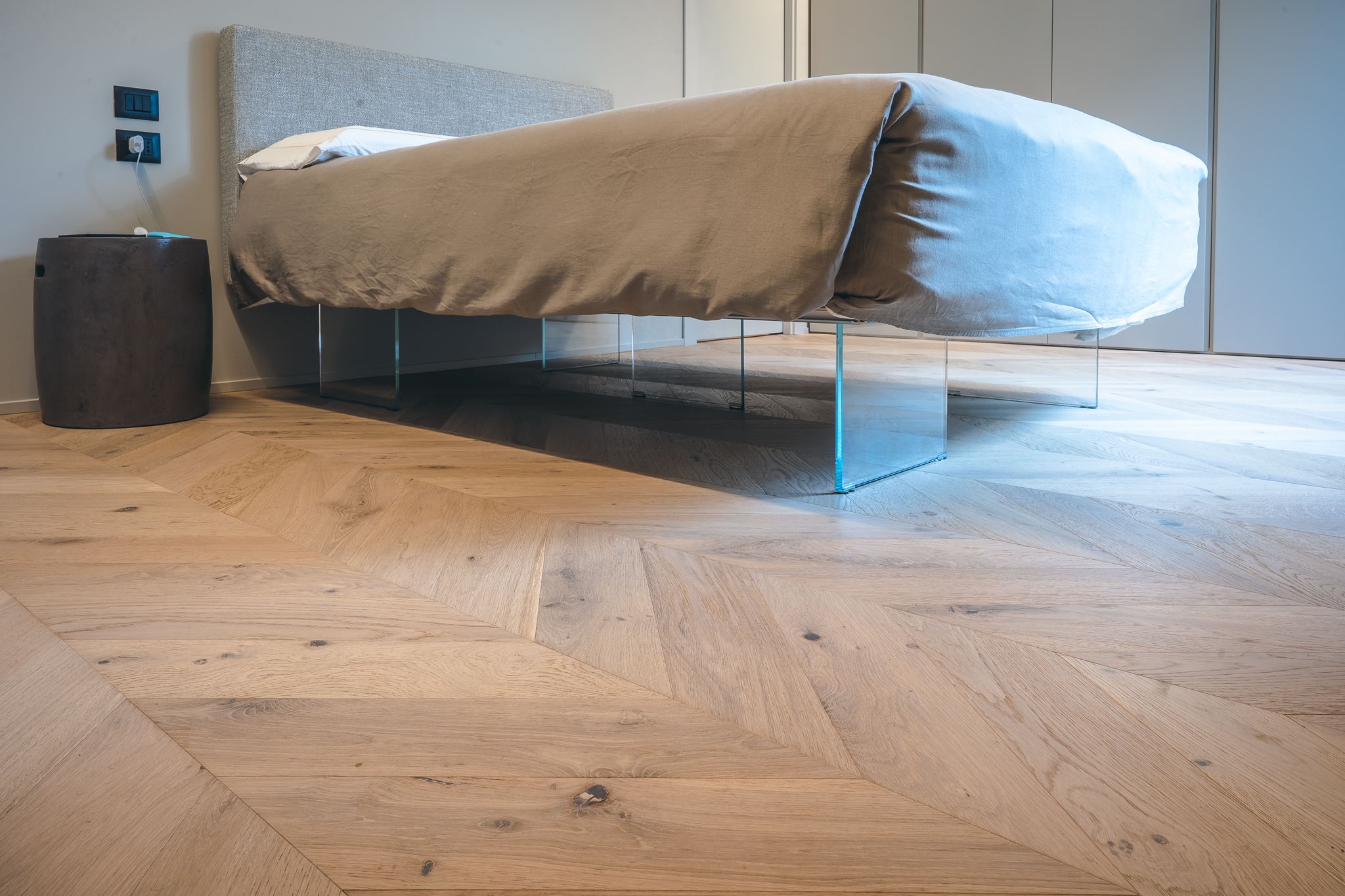 Letto su un Parquet a Spina francese in Rovere naturalizzato di Cabbia