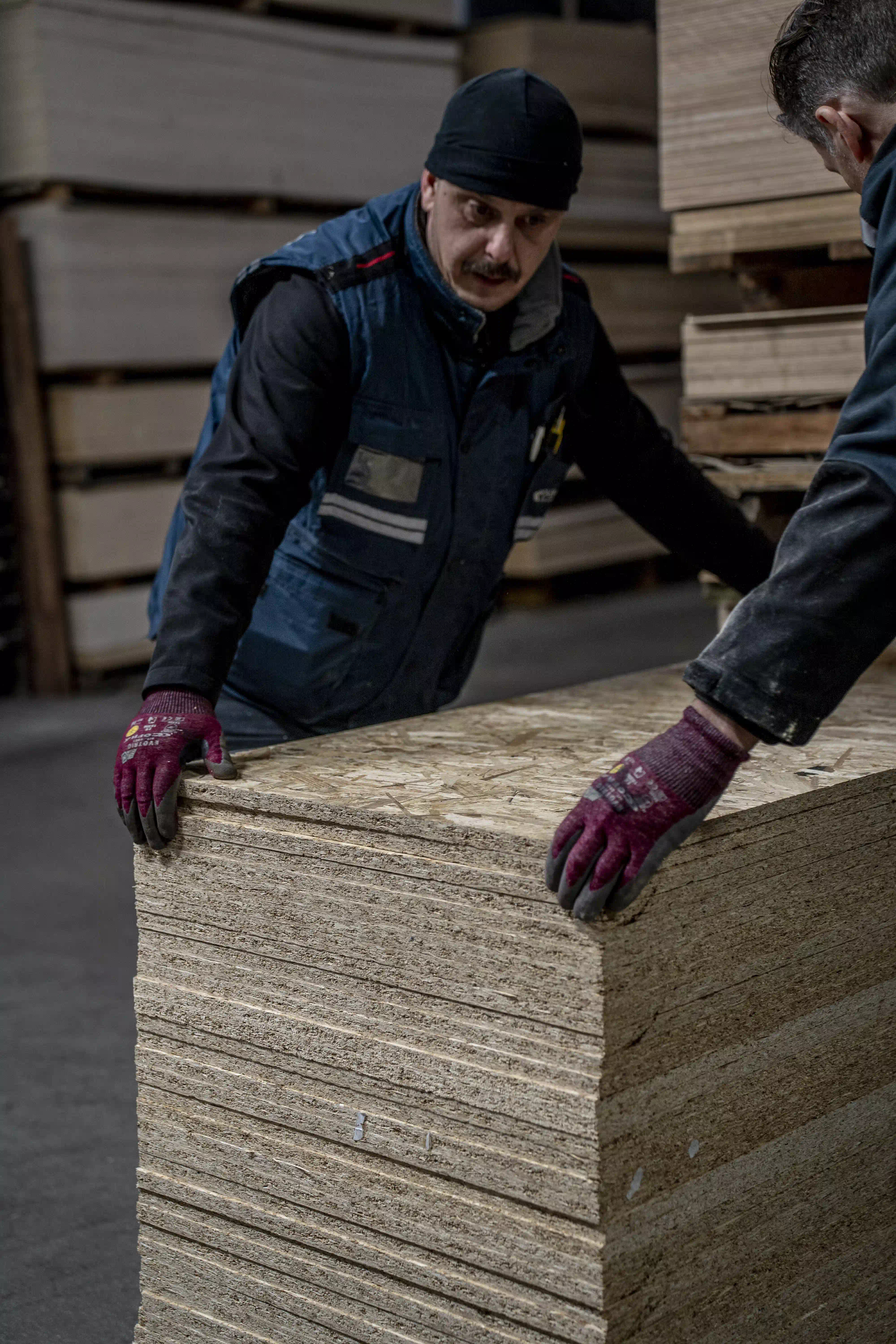 Artigiani di Cabbia che spostano pannelli di compensato