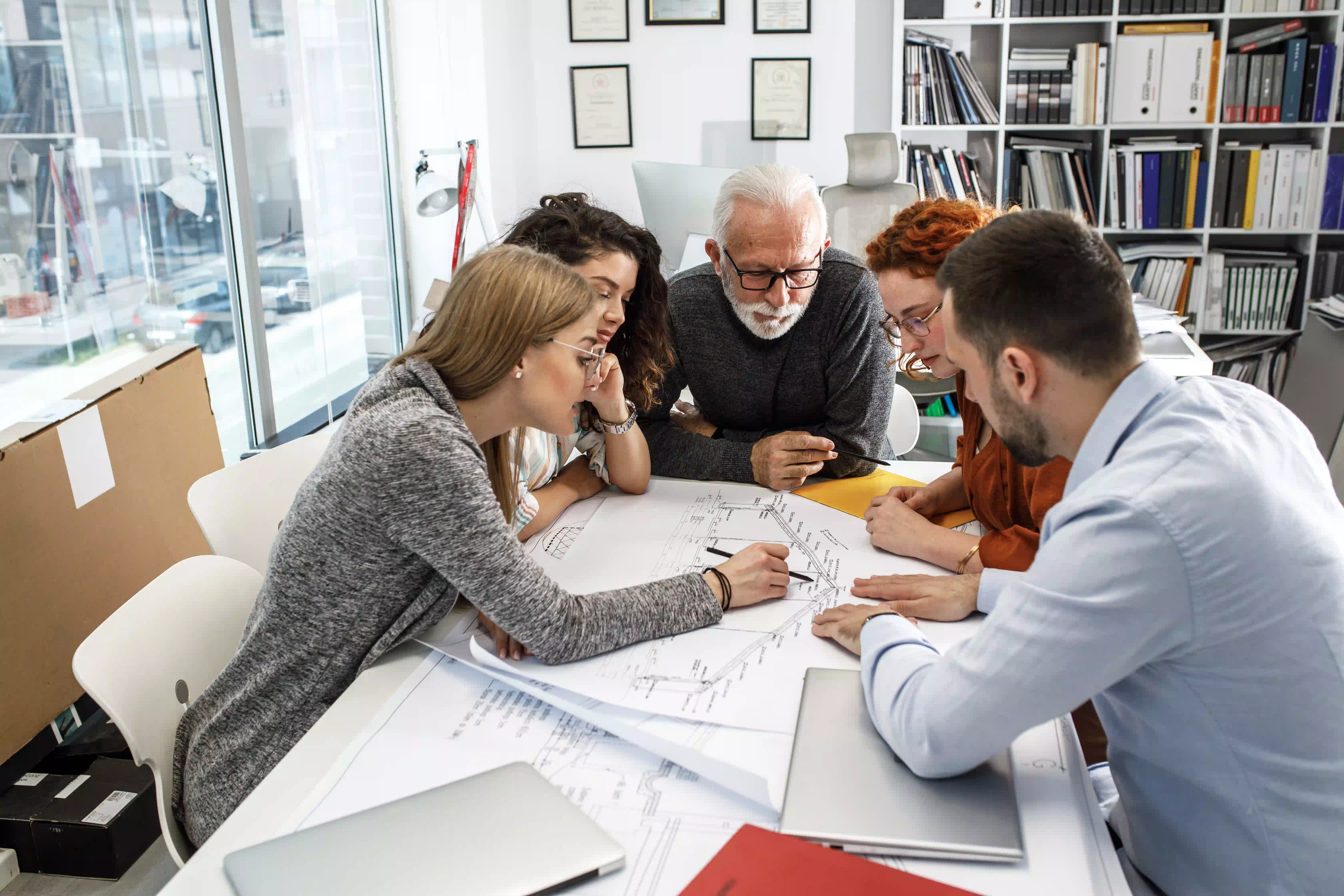 Persone sedute attorno ad un tavolo che progettano un lavoro