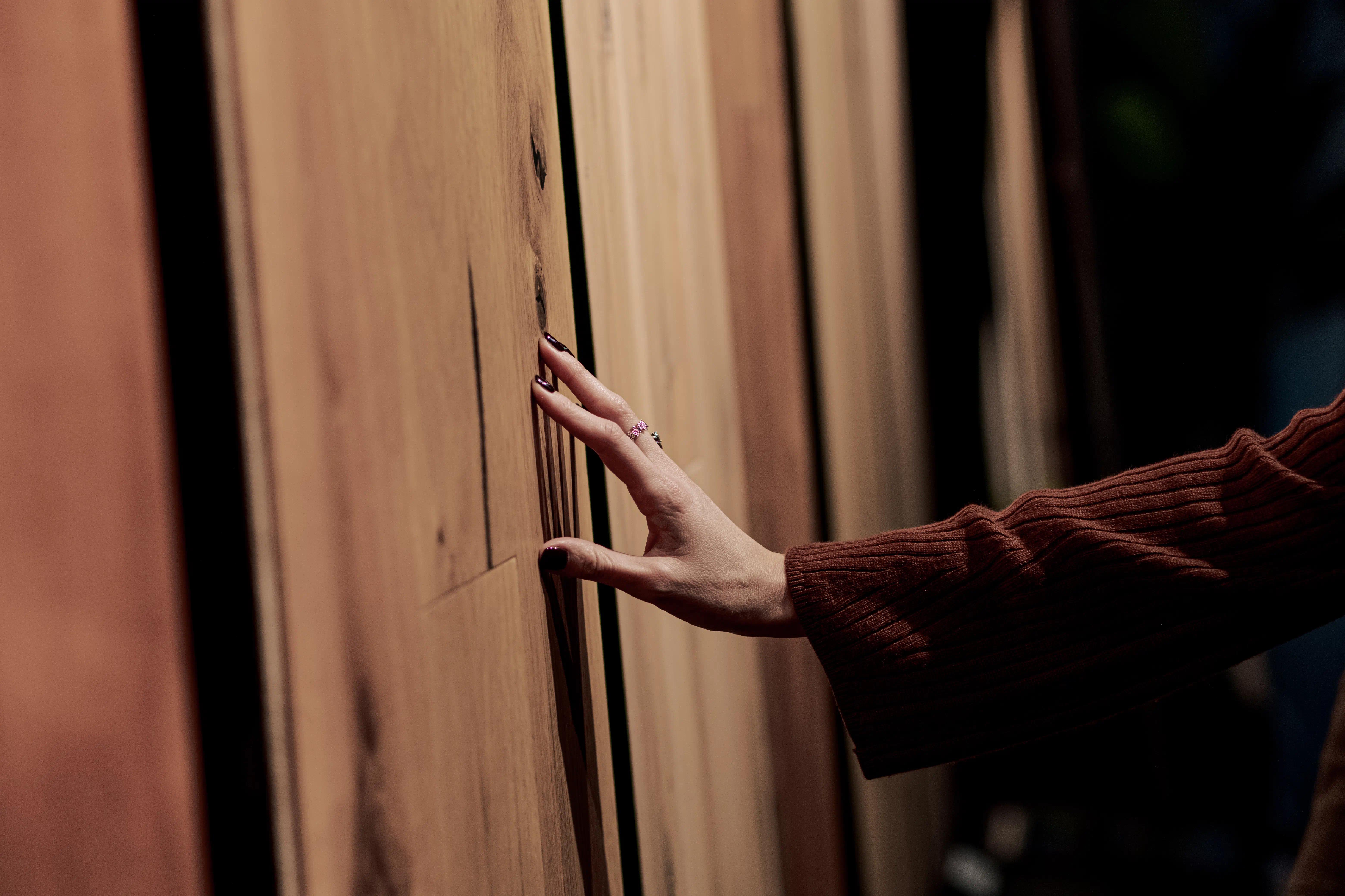 Mano femminile che tocca asse di parquet Cabbia