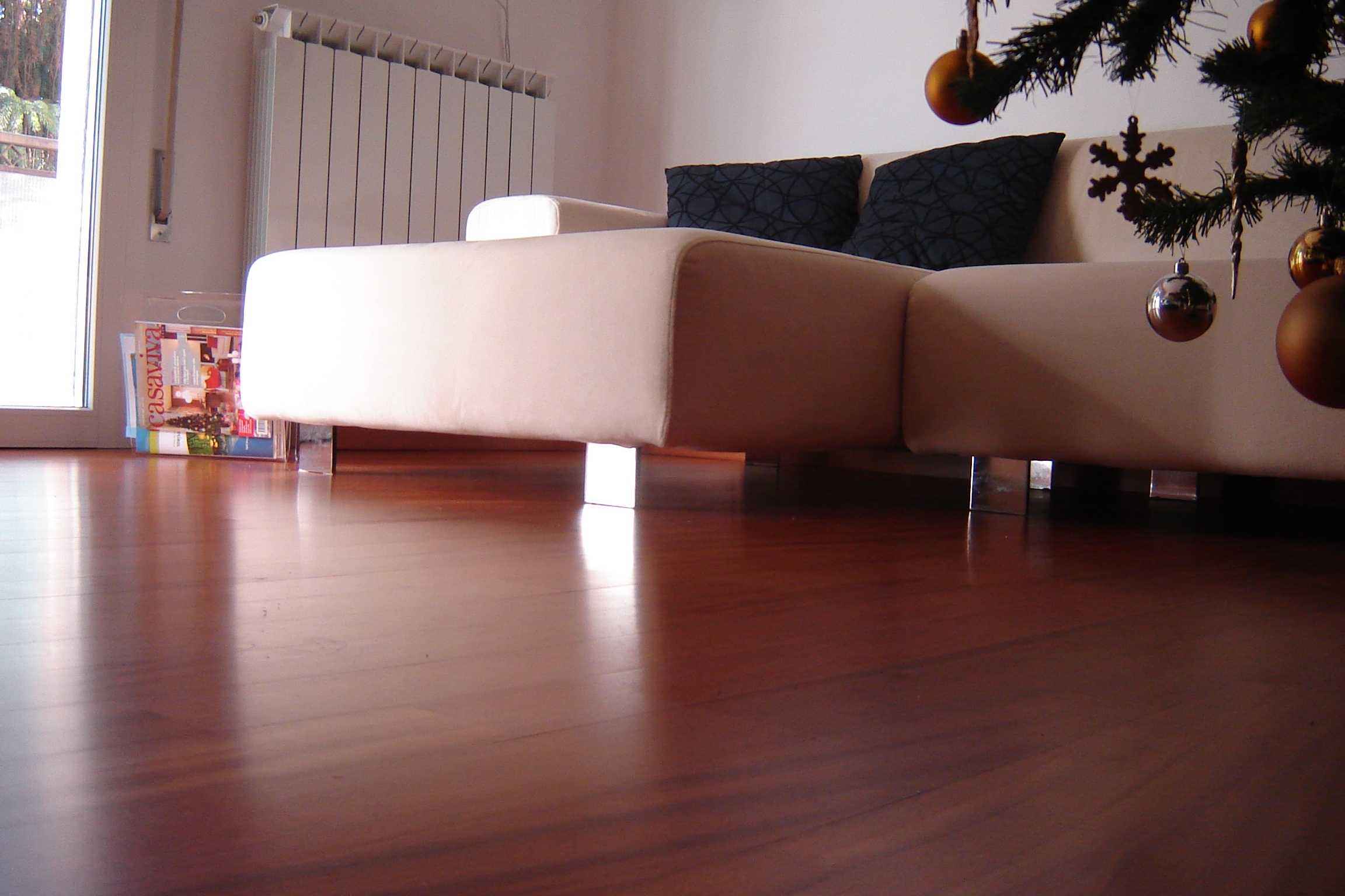 Divano su un parquet Doussiè Verniciato Liscio di Cabbia