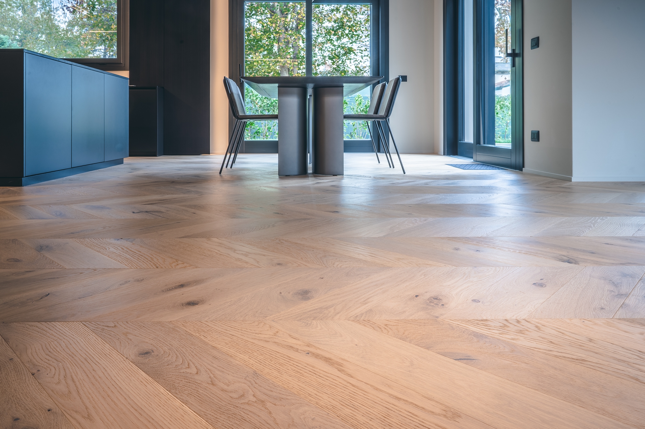 Tavolo e sedie su un Parquet a Spina francese in Rovere naturalizzato di Cabbia