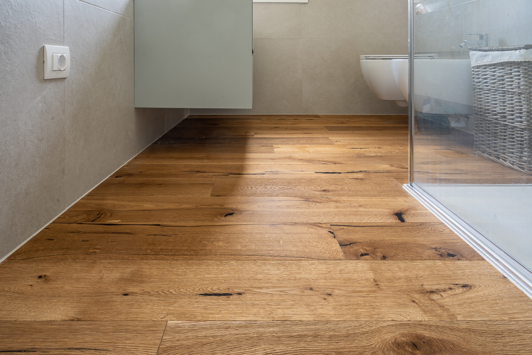 un bagno con pavimento in legno