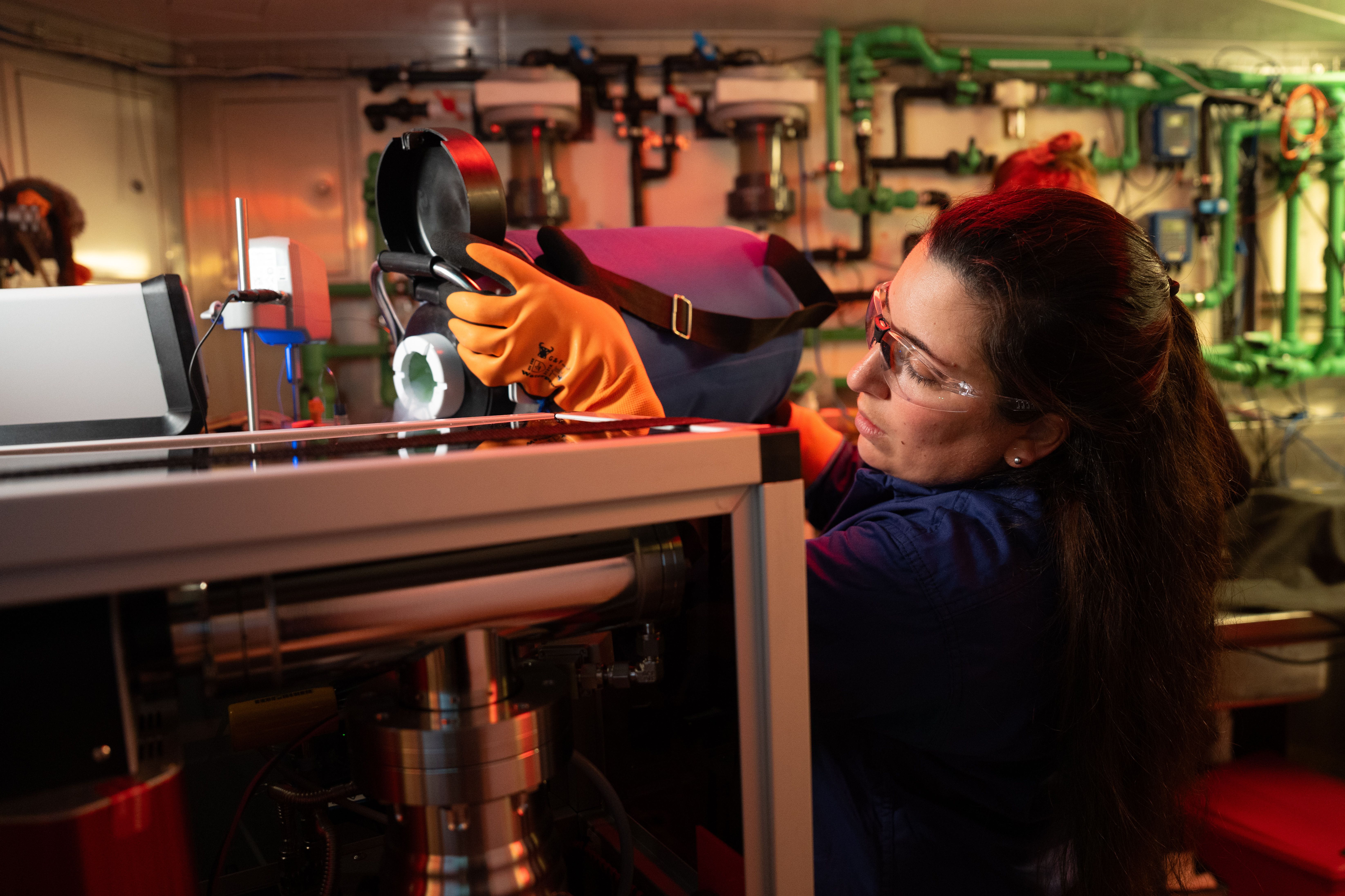 A scientist adds chemicals to a container in a seawater lab 