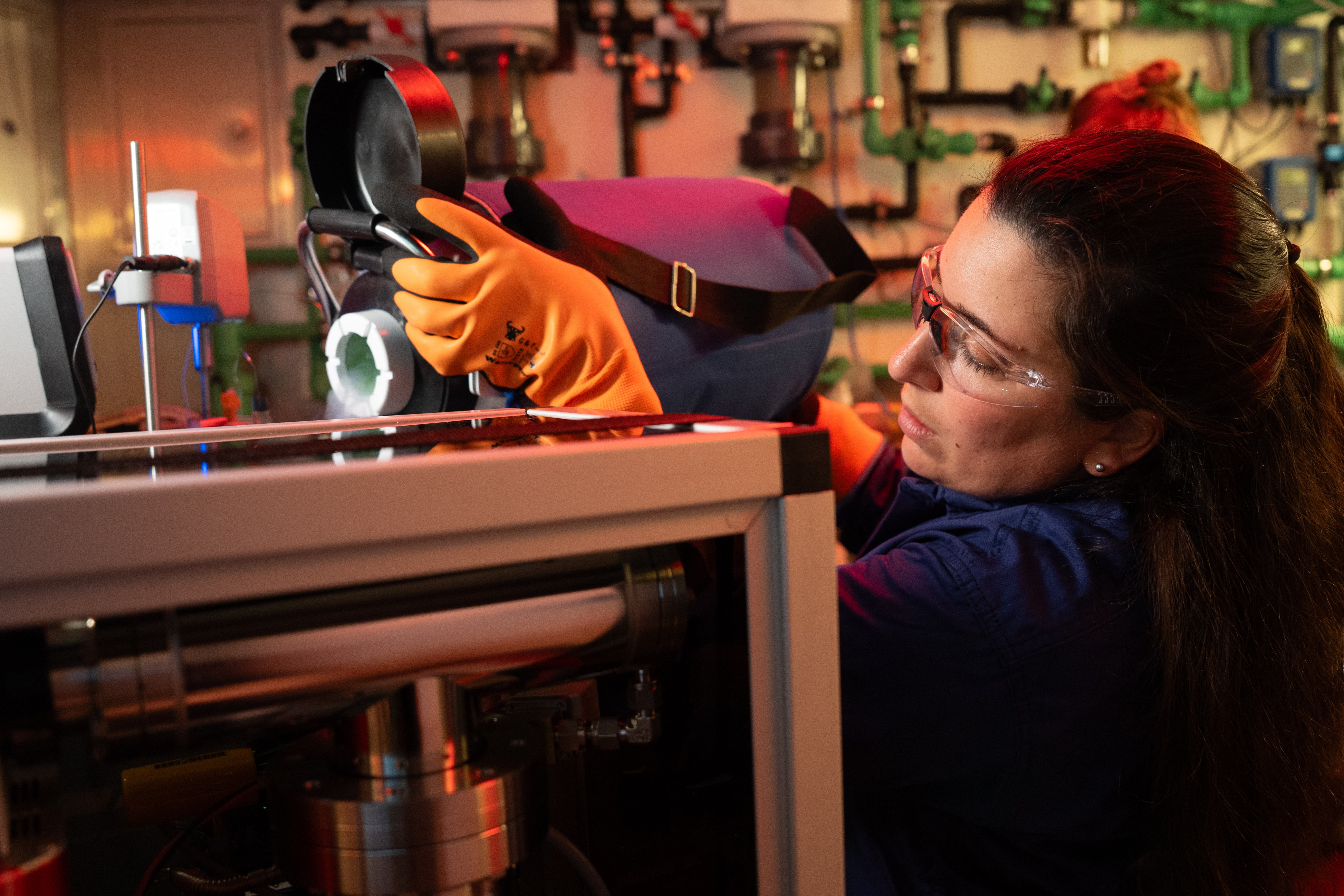 A scientist adds chemicals to a container in a seawater lab
