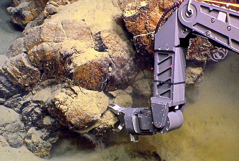Collecting a rock sample at Loihi on a past expedition.