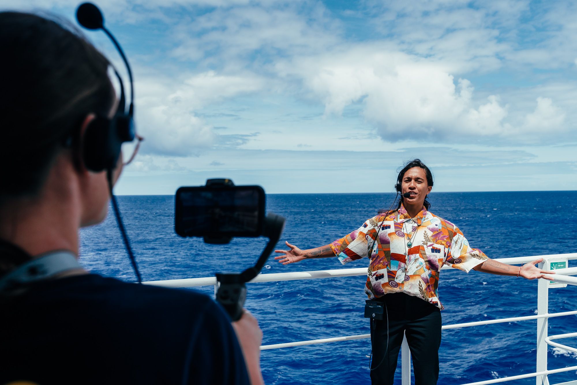 person standing in front of a camera on the deck of a ship