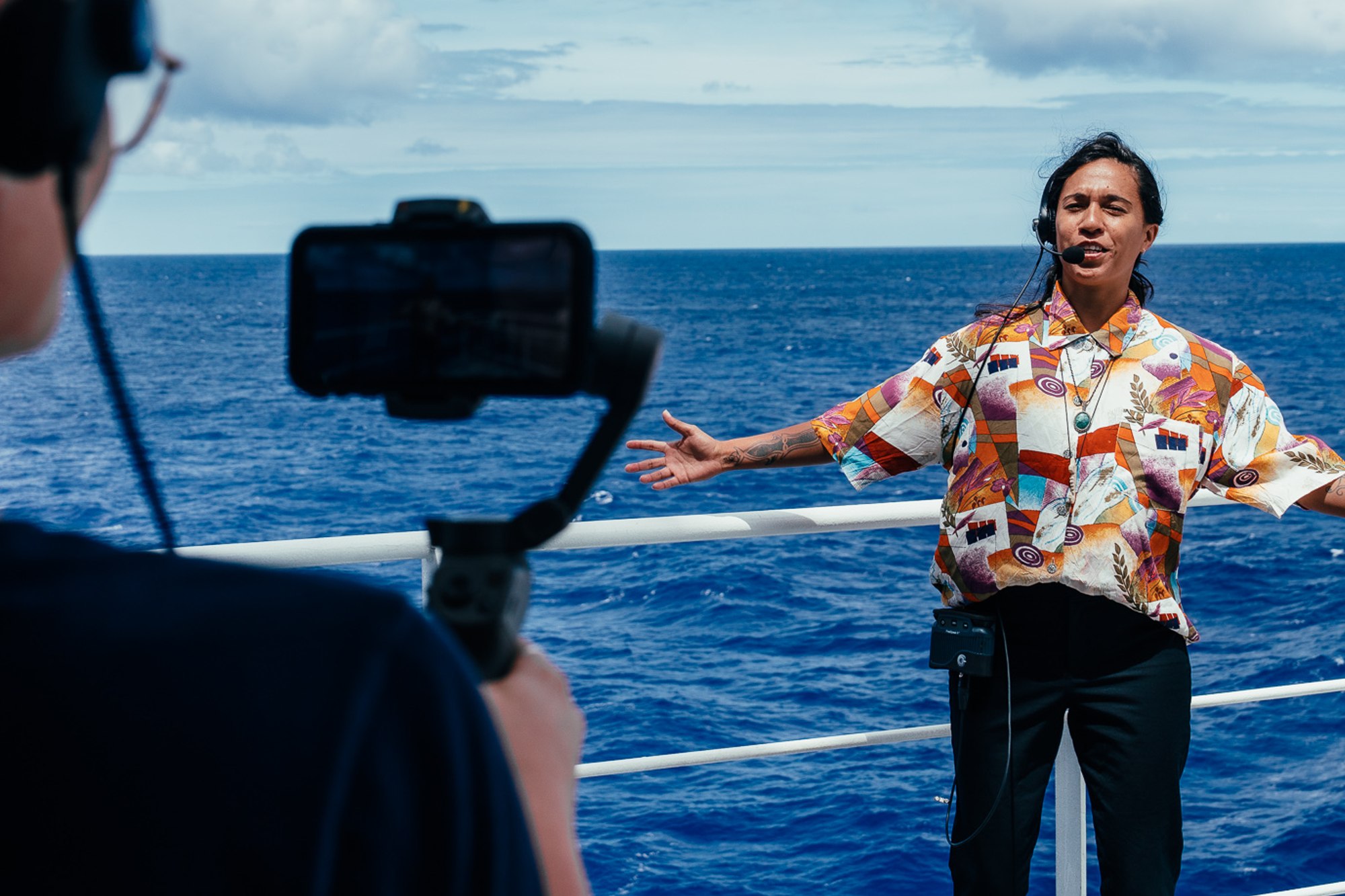 person standing in front of a camera on the deck of a ship
