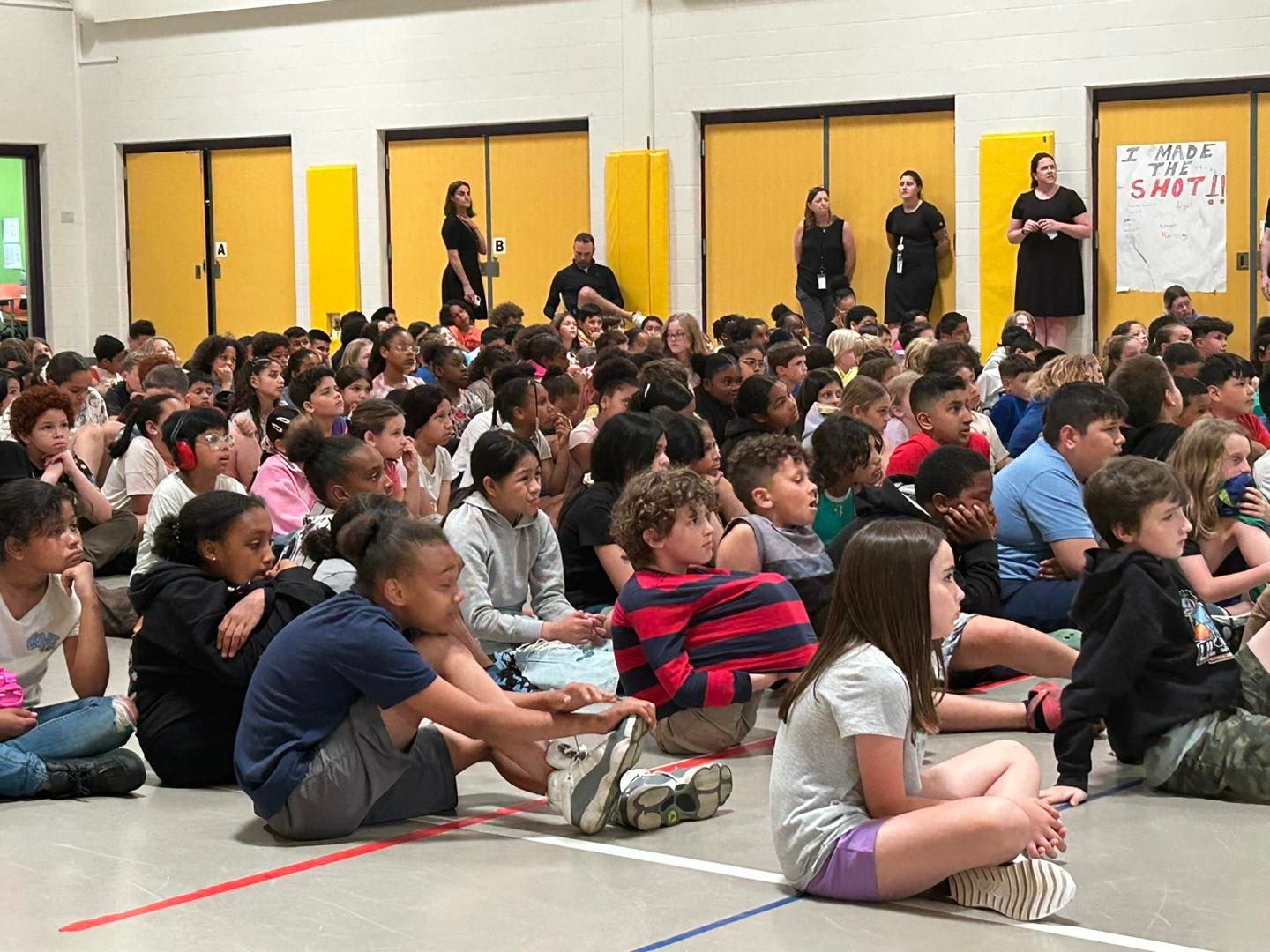 Young children sitting on floor in gymnasium