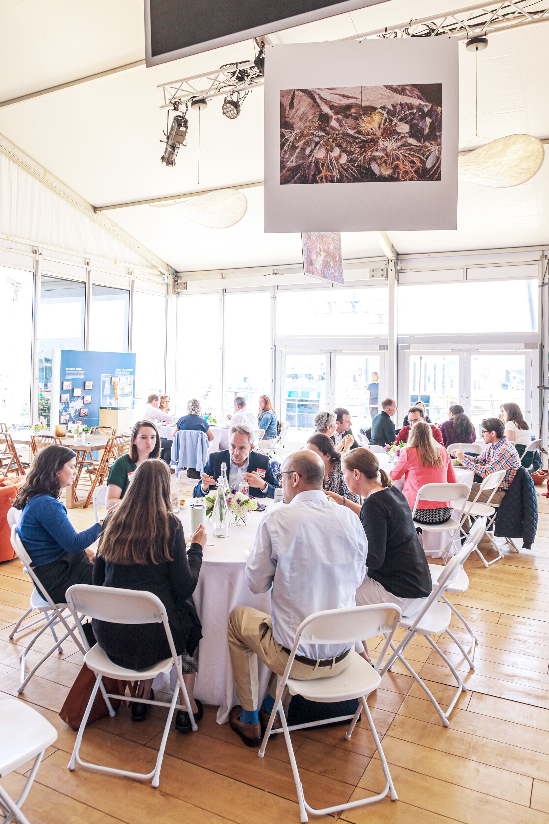 people sitting at round tables in an event space