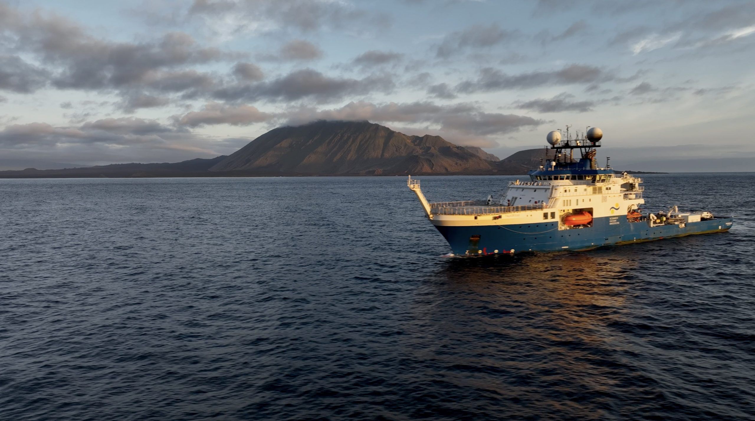 ship on the water with mountain in background