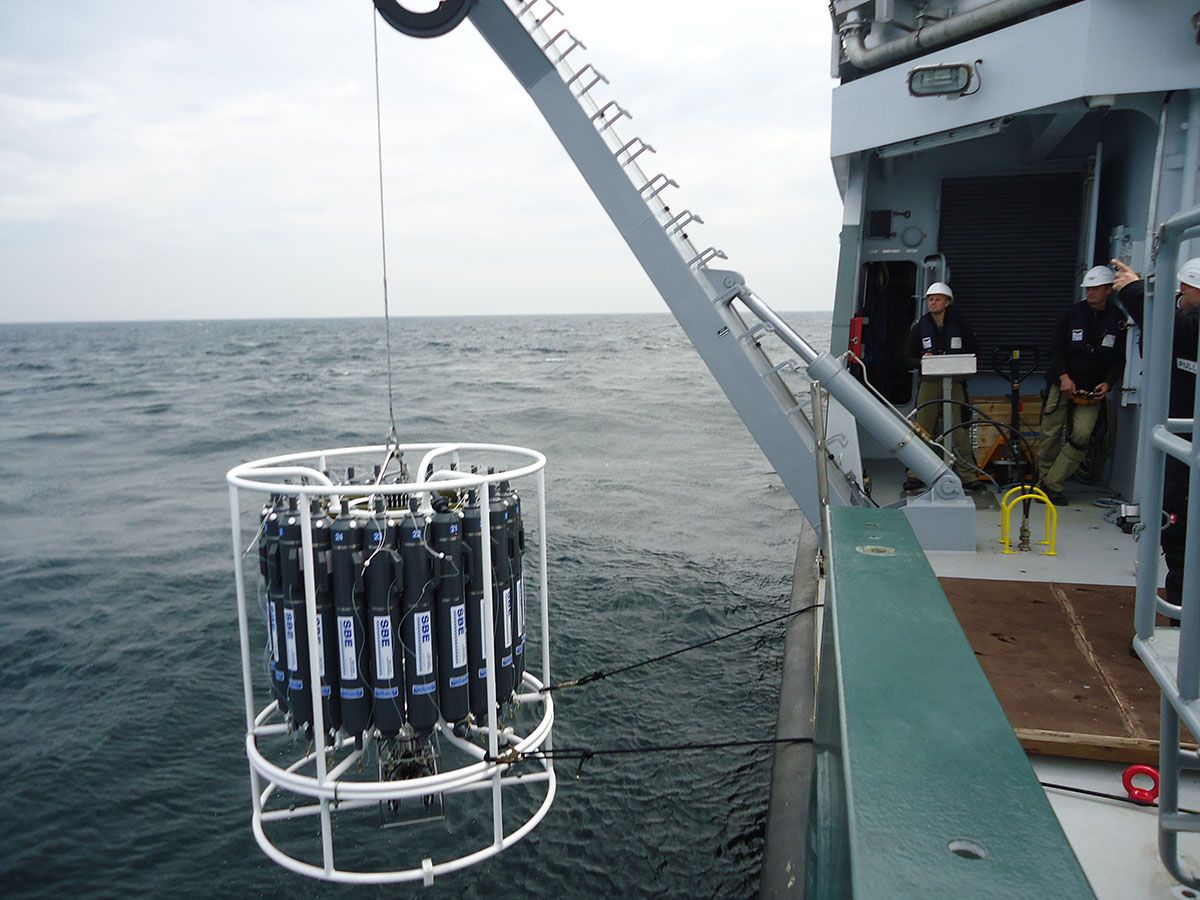 The 24-bottle CTD rosette being launched over the side of the R/V Falkor. The rosette will be used to collect water samples throughout the water column at various depths.
