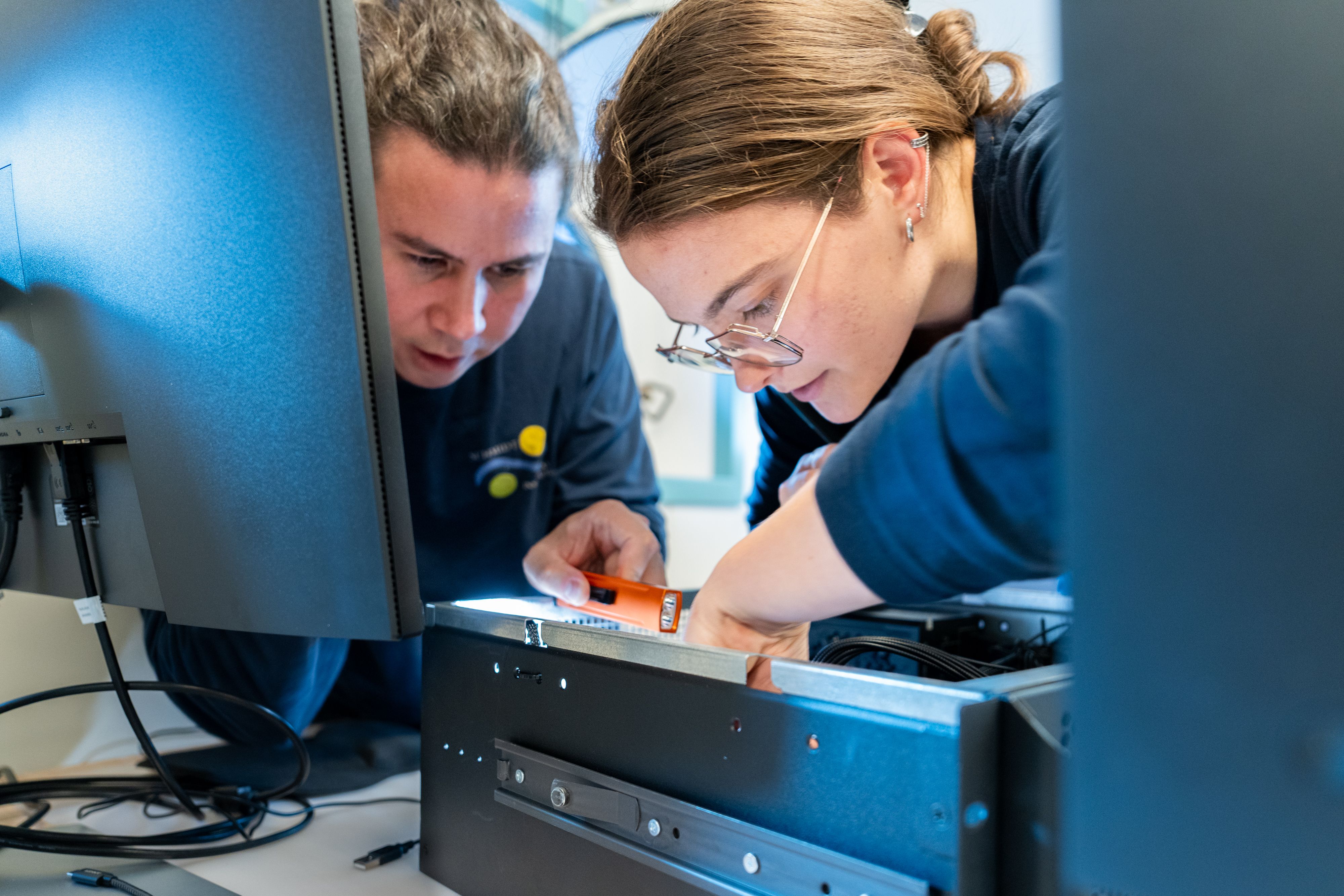 Technicians work on configurations for a new computer. 