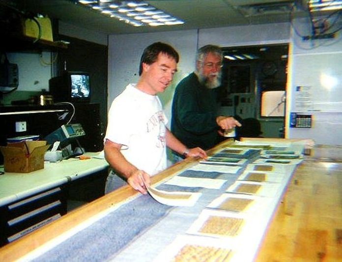 Mike Coffin from the University of Tasmania and José Honnorez from the Université de Strasbourg in France reviewing data aboard the scientific ocean drilling vessel JOIDES Resoltuion during a 2000 expedition.
