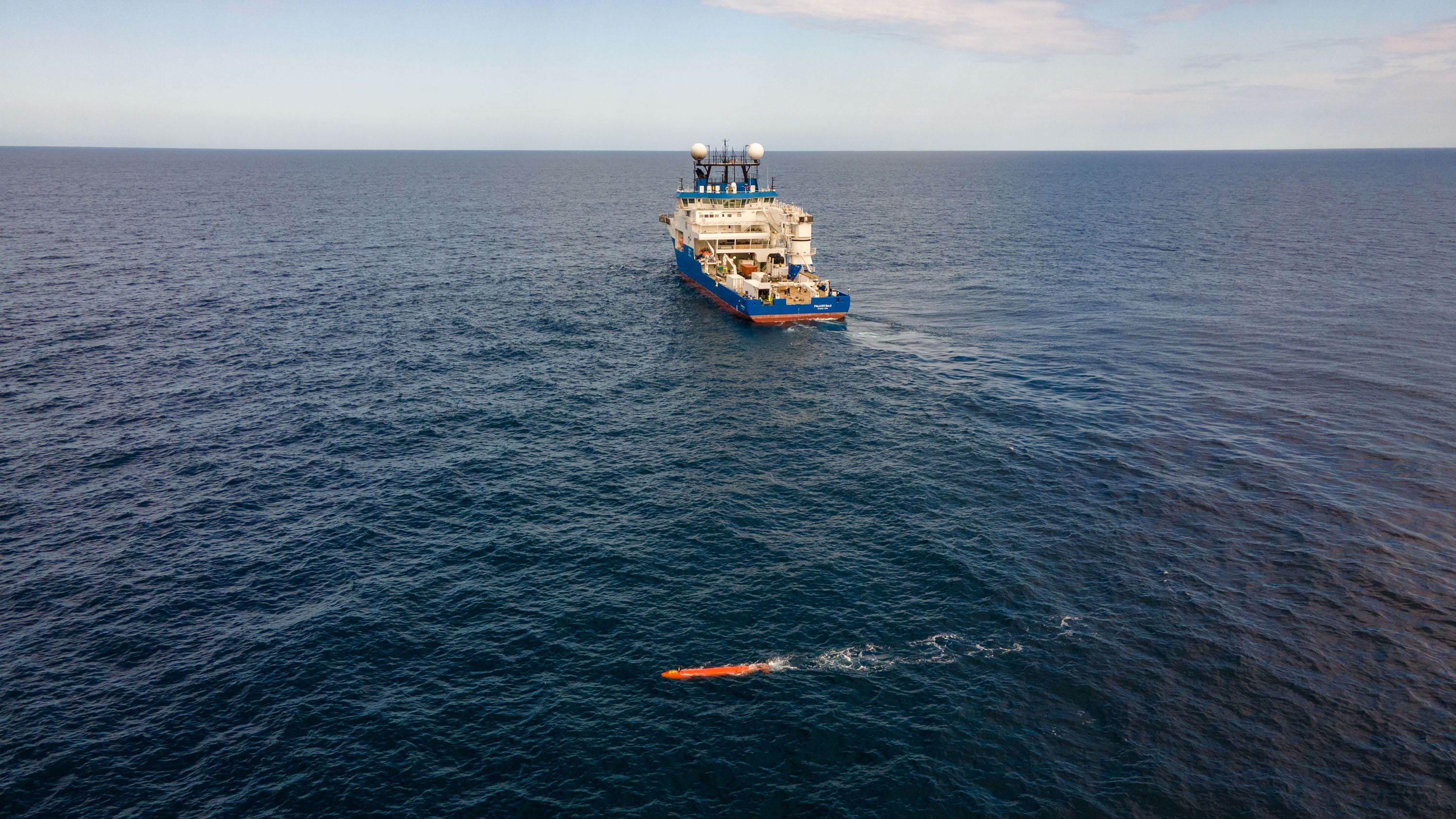 Aerial view of the RV Falkor (too) with the AUV in the water.