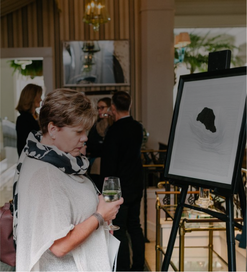 person standing in front of painting on easel