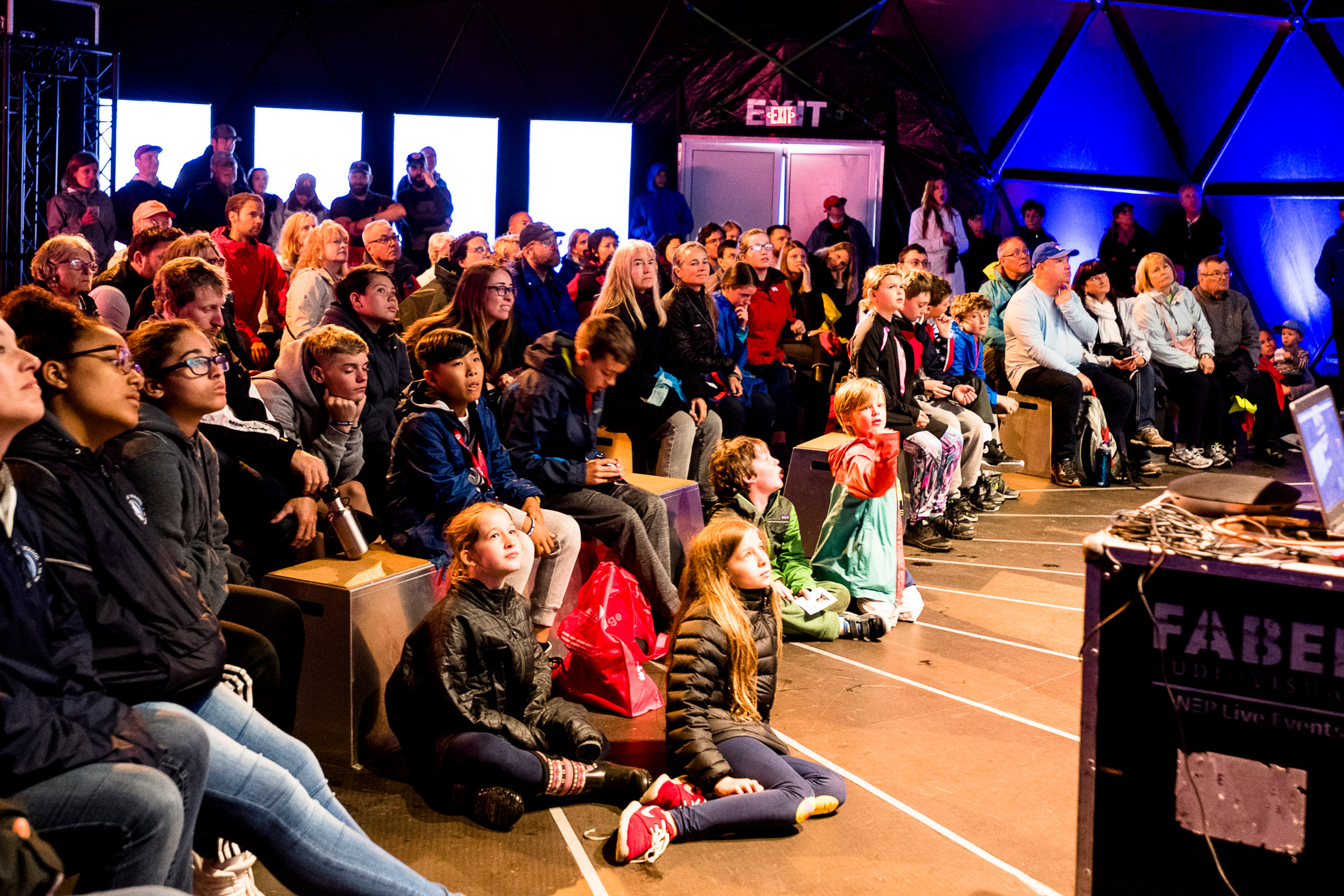 Children and families watching a projection of a conversation