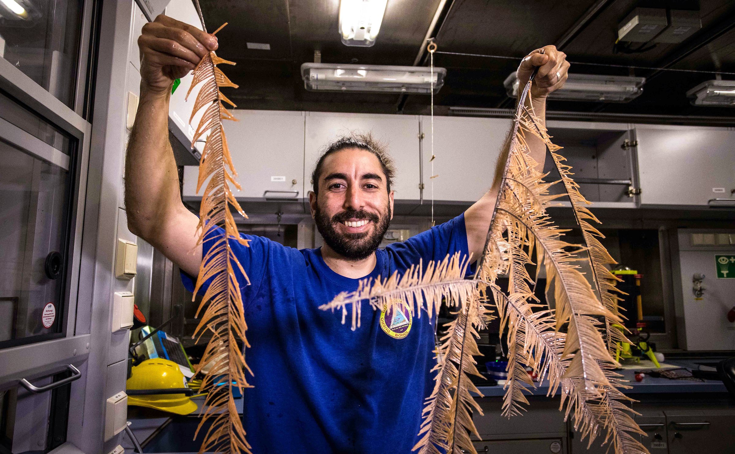 Scientists holding up long corals