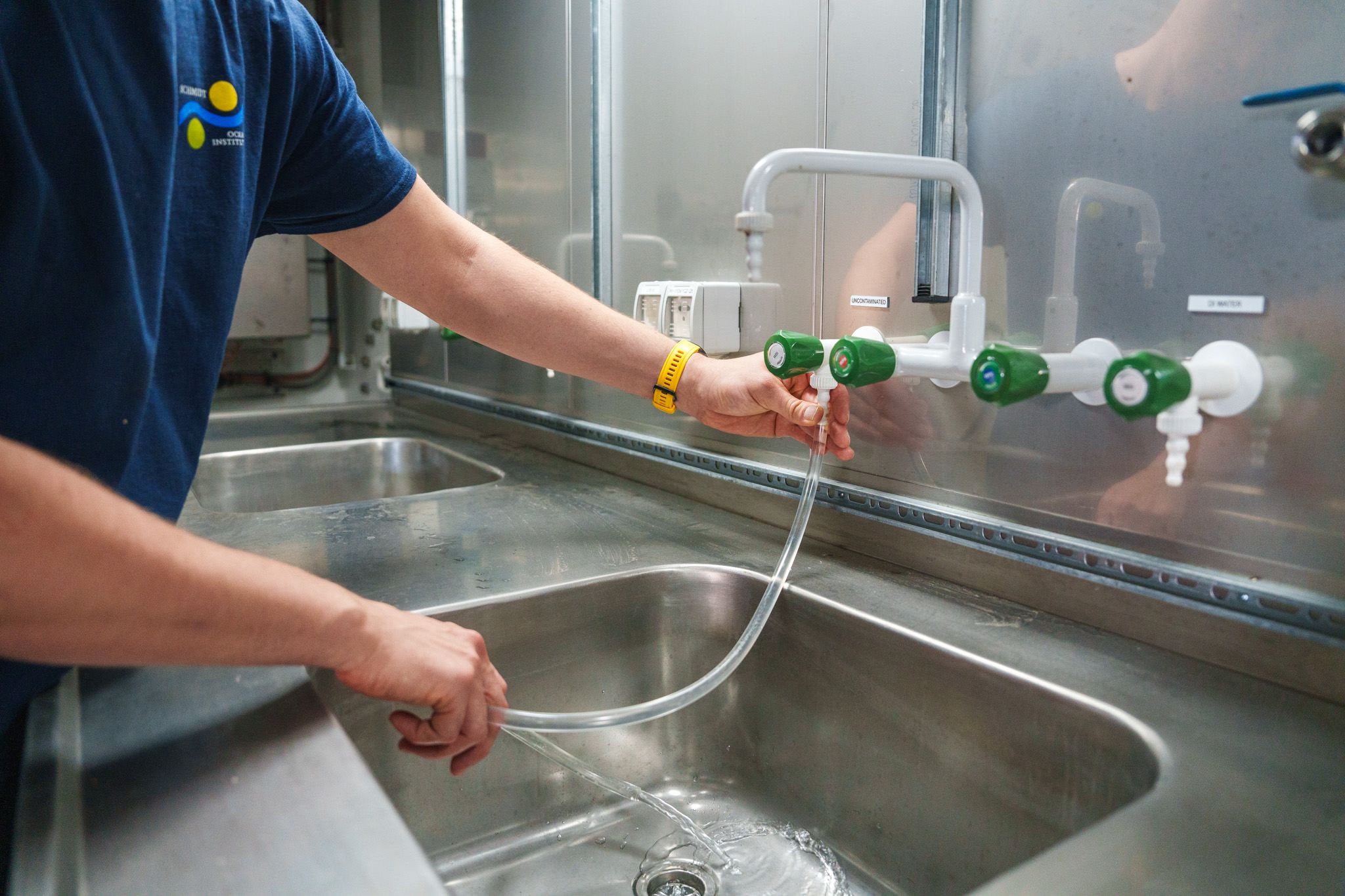Laboratory tap with a technician connecting a tube to dispense seawater.  