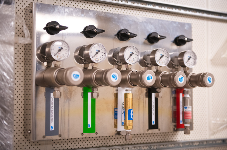 several gas taps with different colors which are marked to carry certain gases to the labs. 