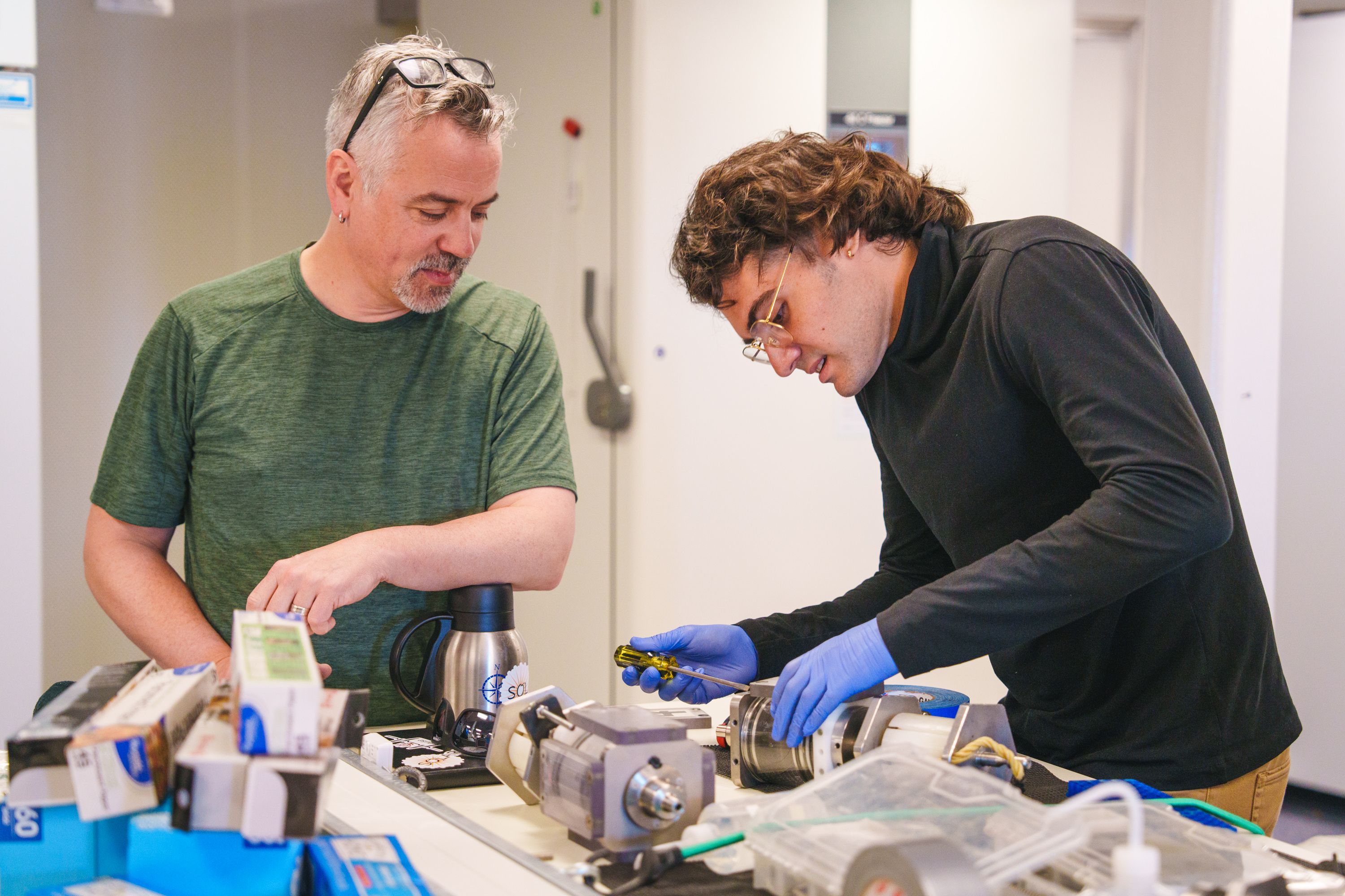 two people working on a device together
