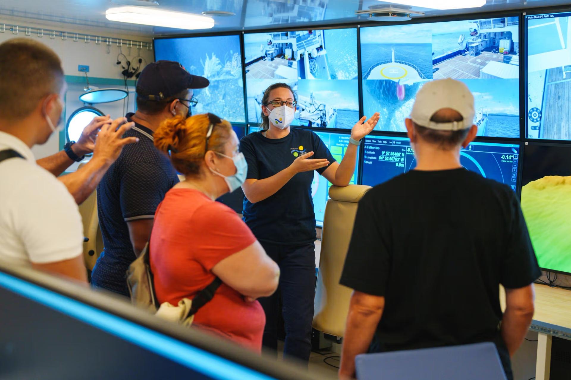 Marine technician talking to a group of scientists.