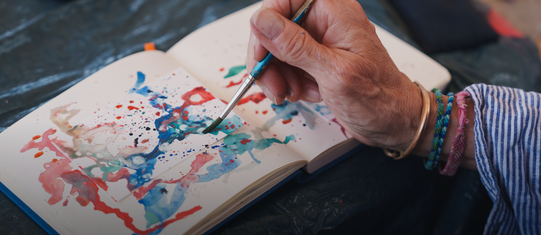 close up of a hand painting with watercolor paints