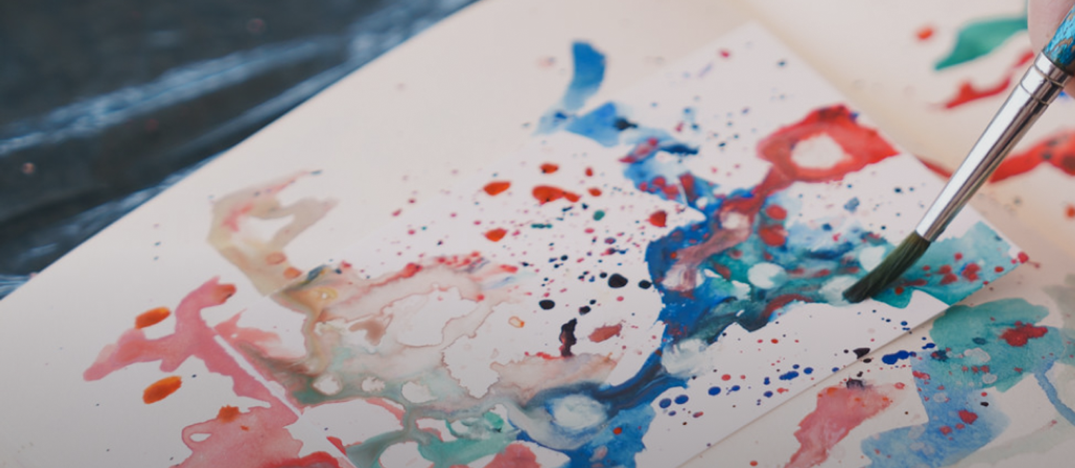 close up of a hand painting with watercolor paints