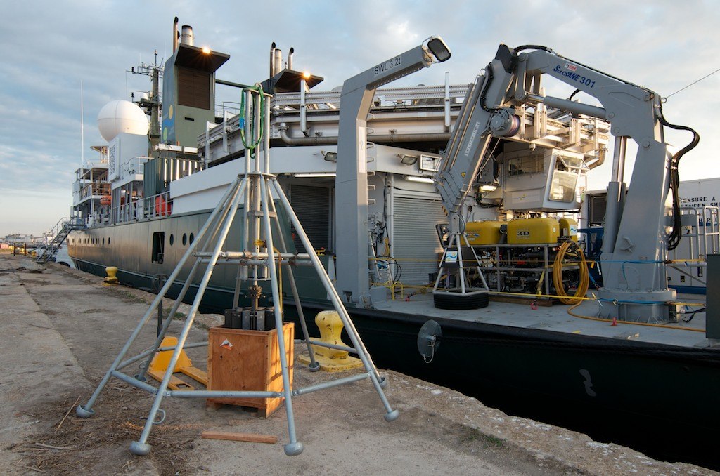 Scientists assemble the multicore instrument from shipping containers on the dock before loading it onto R/V Falkor.