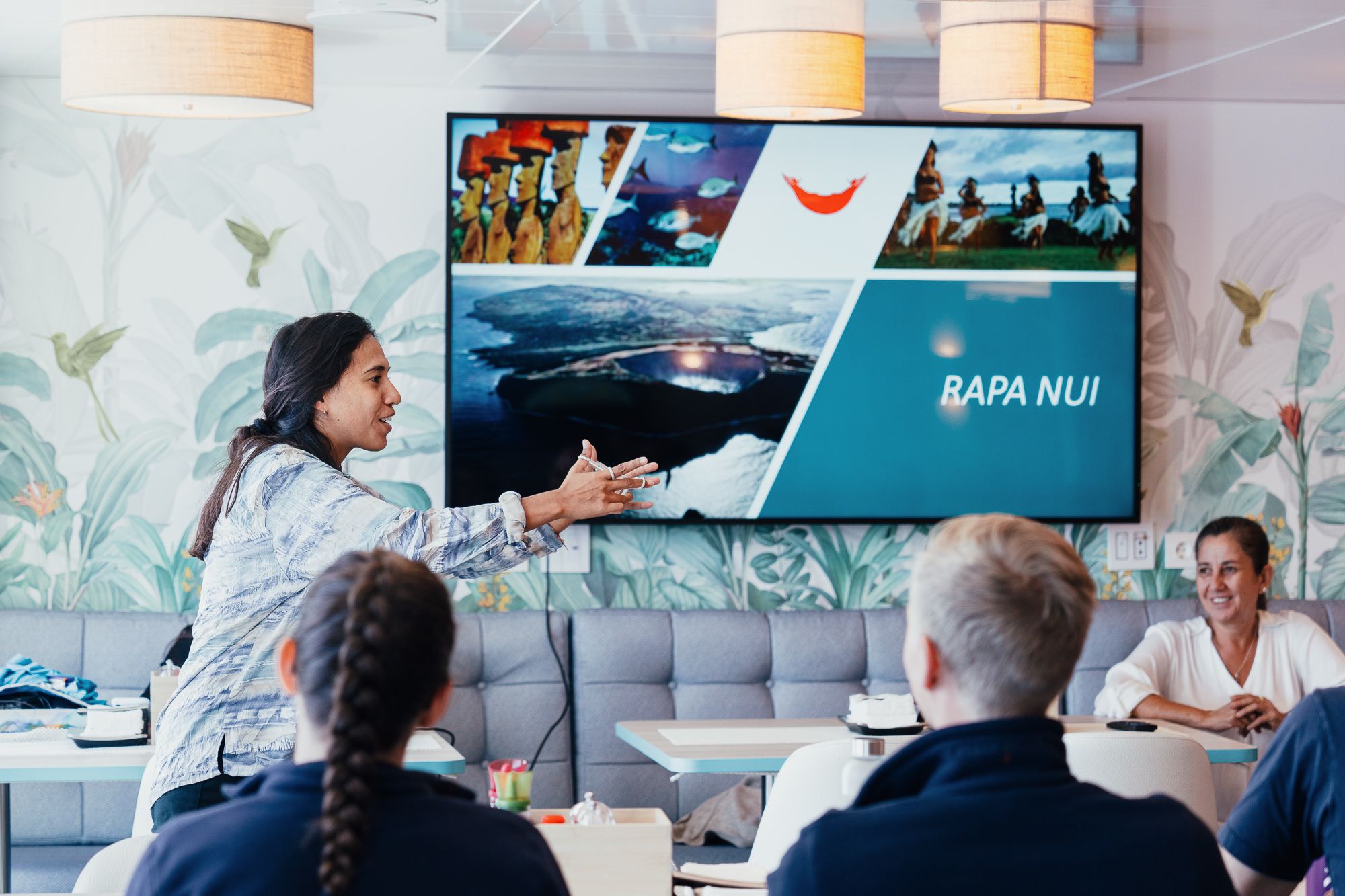 person presenting to small group of people with presentation on screen