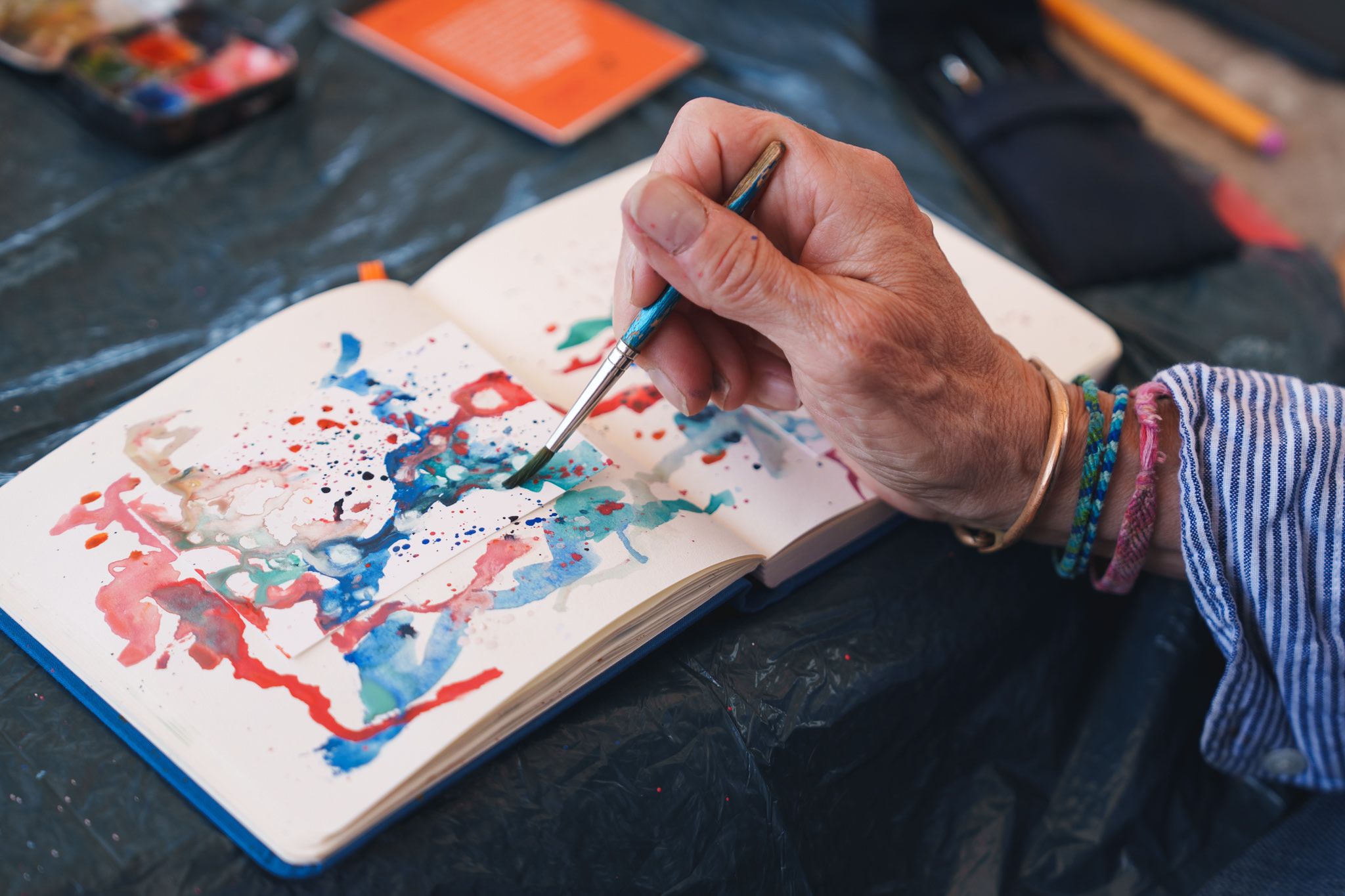 close up of a hand painting with watercolor paints