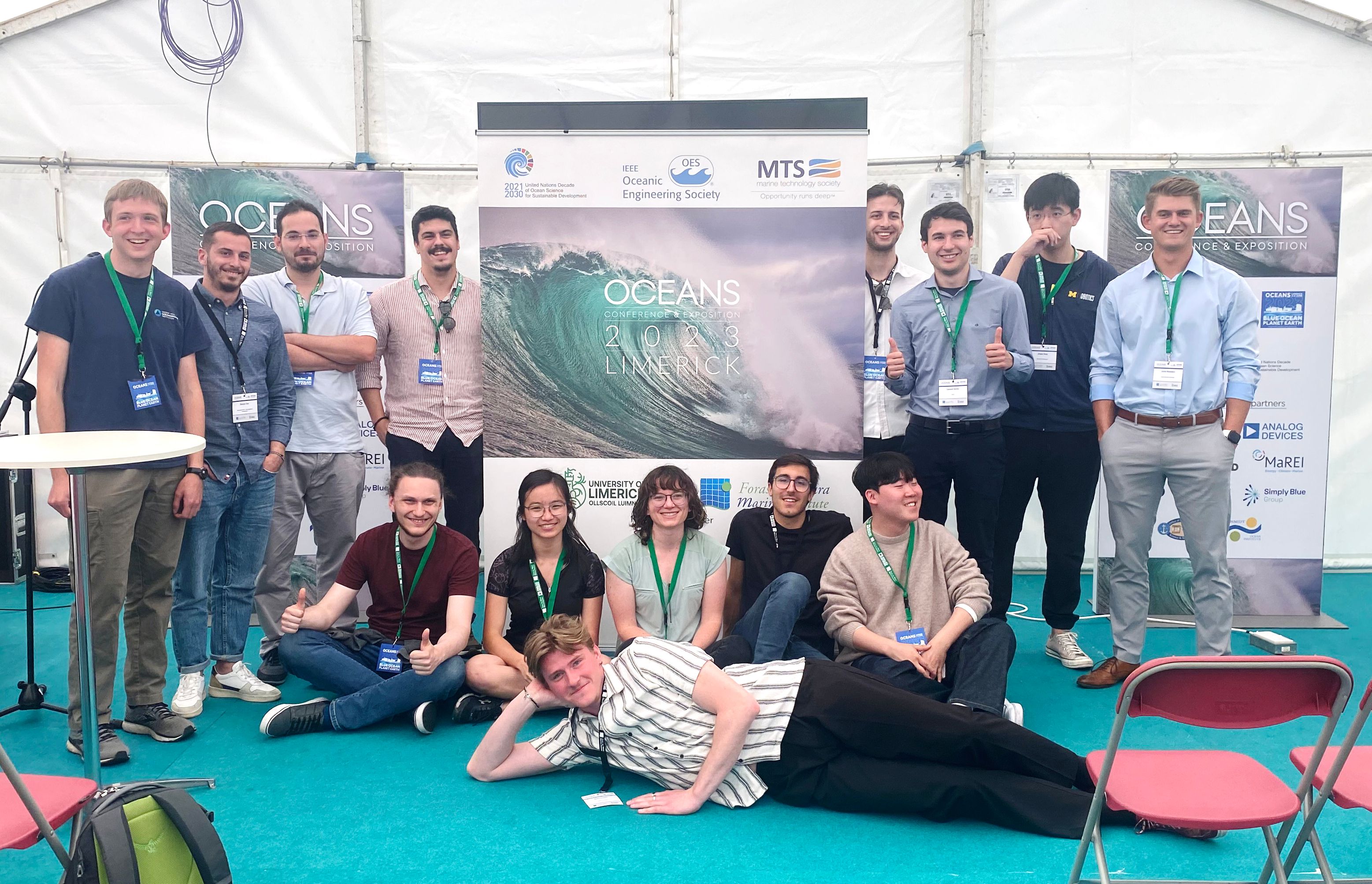 group of people in front of a poster display 