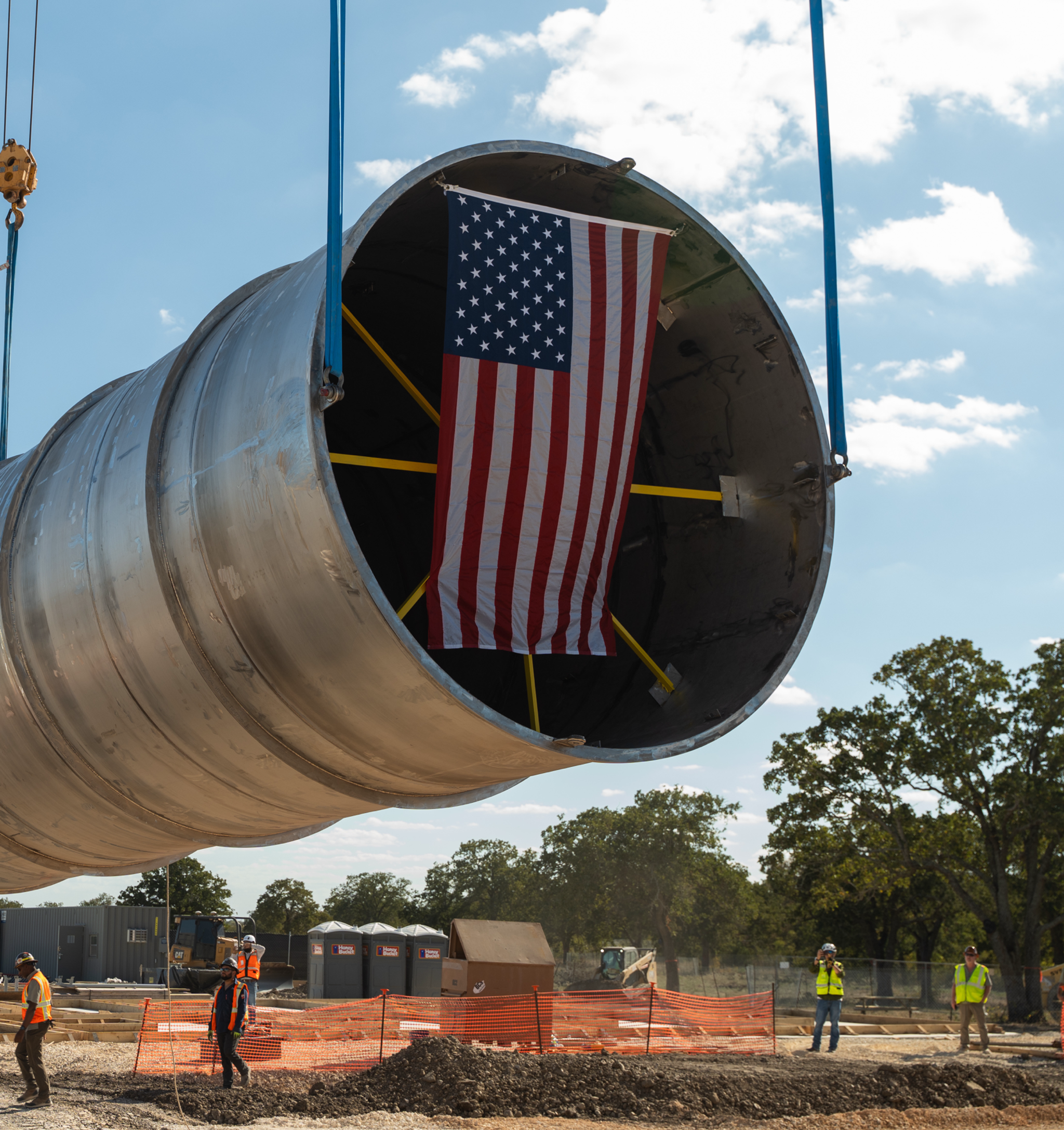 Large pipe section being installed with an American flag visible inside