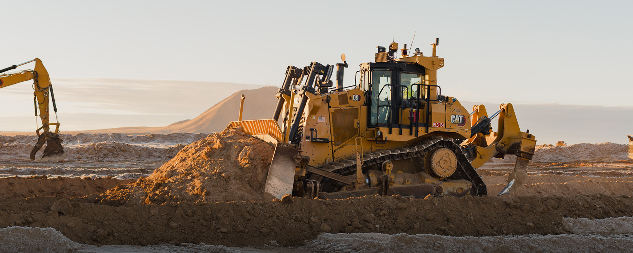 Excavator grading the Aurora construction site
