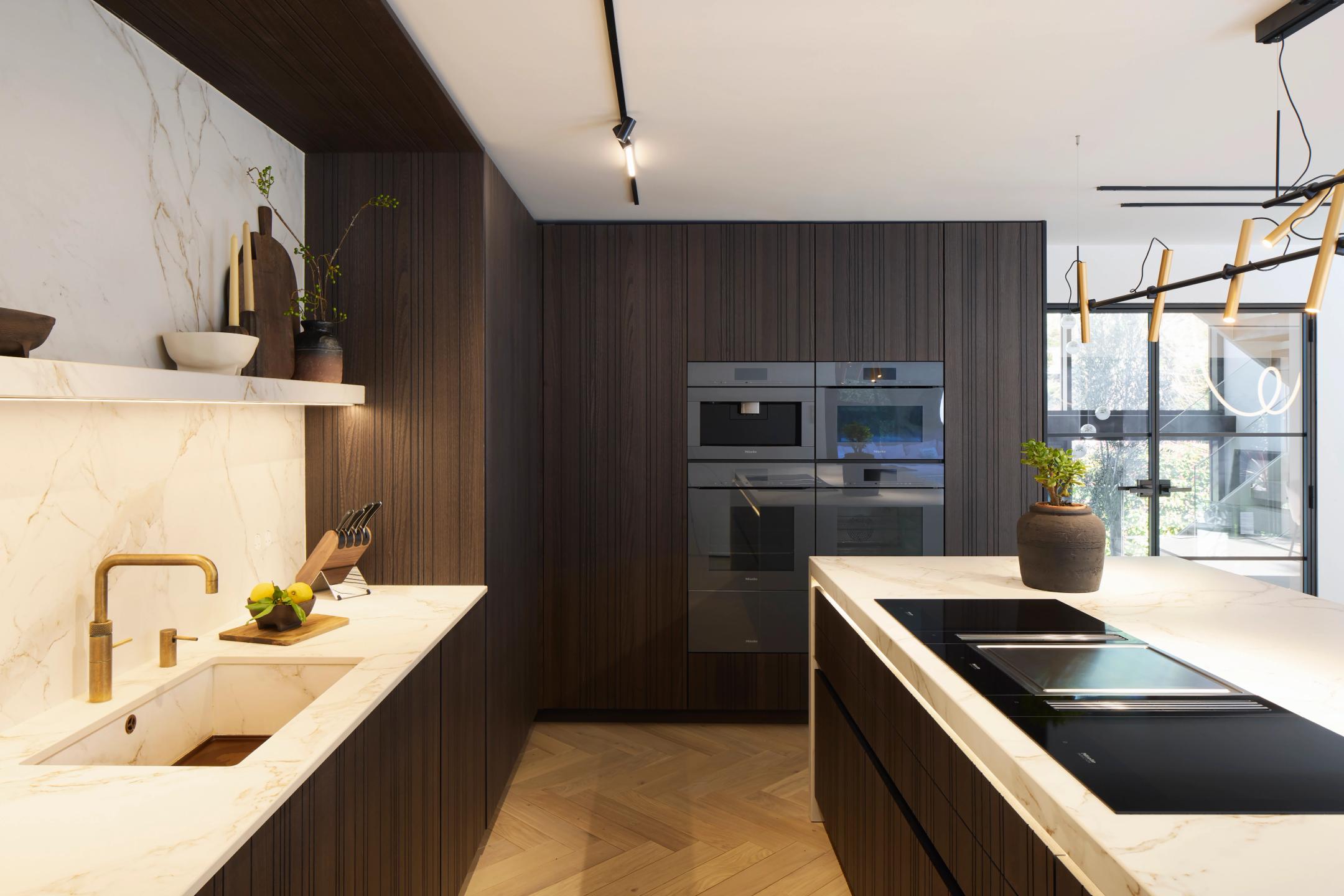 Tepan Yaki and induction hob with integrated ventilation along with Dekton floating shelf with integrated lighting