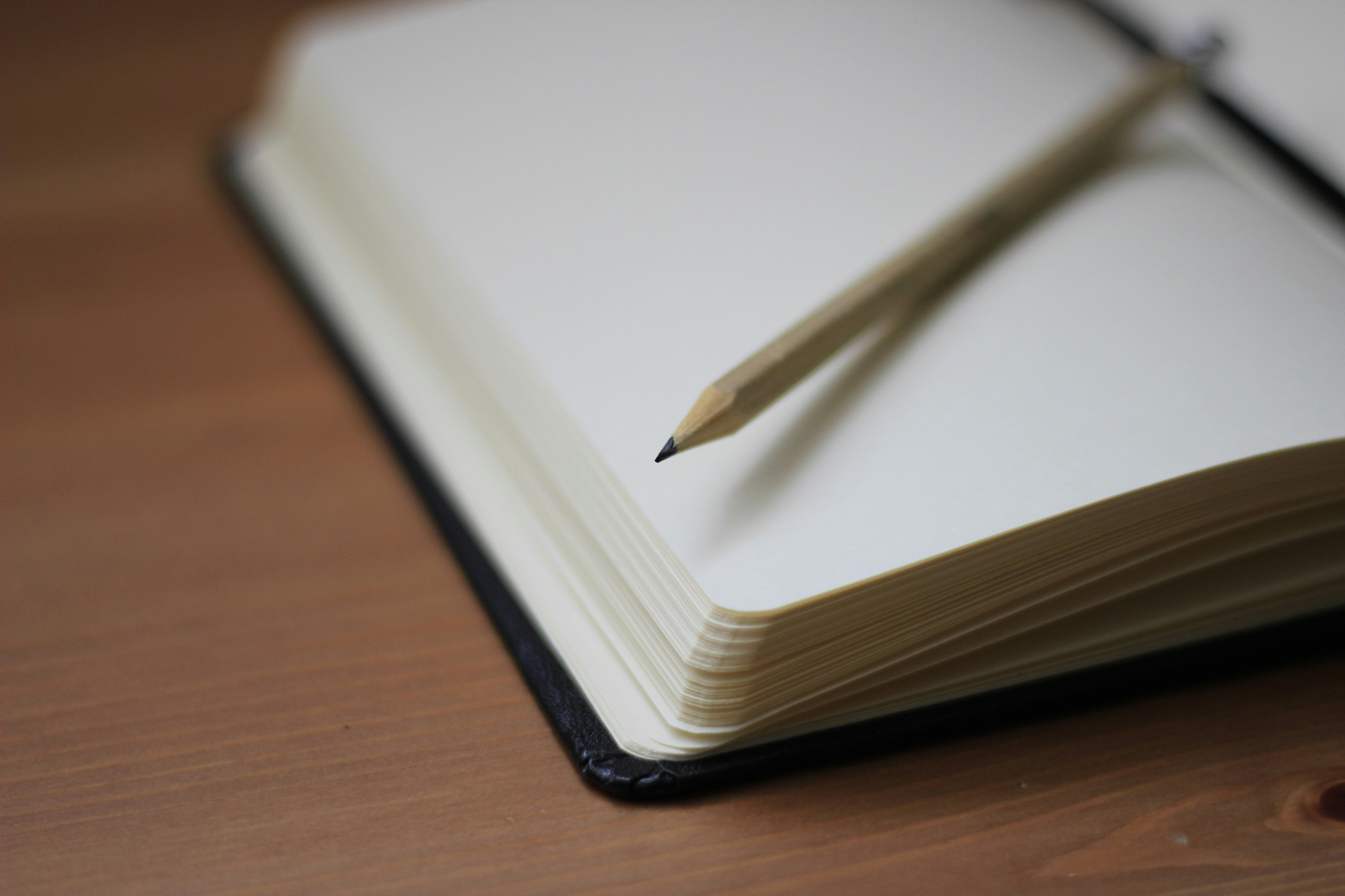 crayon poser sur un carnet aux pages blanches
